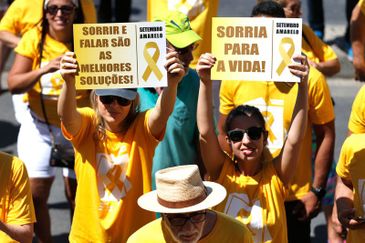 Mulheres exibem cartazes de campanha do Setembro Amarelo