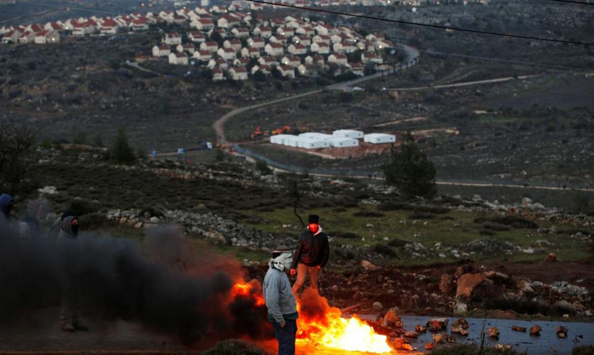 Protesto com queima de pneus próximo na Cisjordânia, depois que Israel anunciou a construção de 3.000 novos alojamentos 