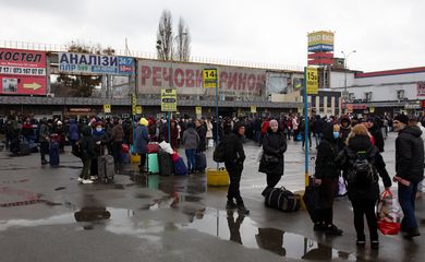 Pessoas se reúnem em uma estação de ônibus enquanto tentam sair de Kiev