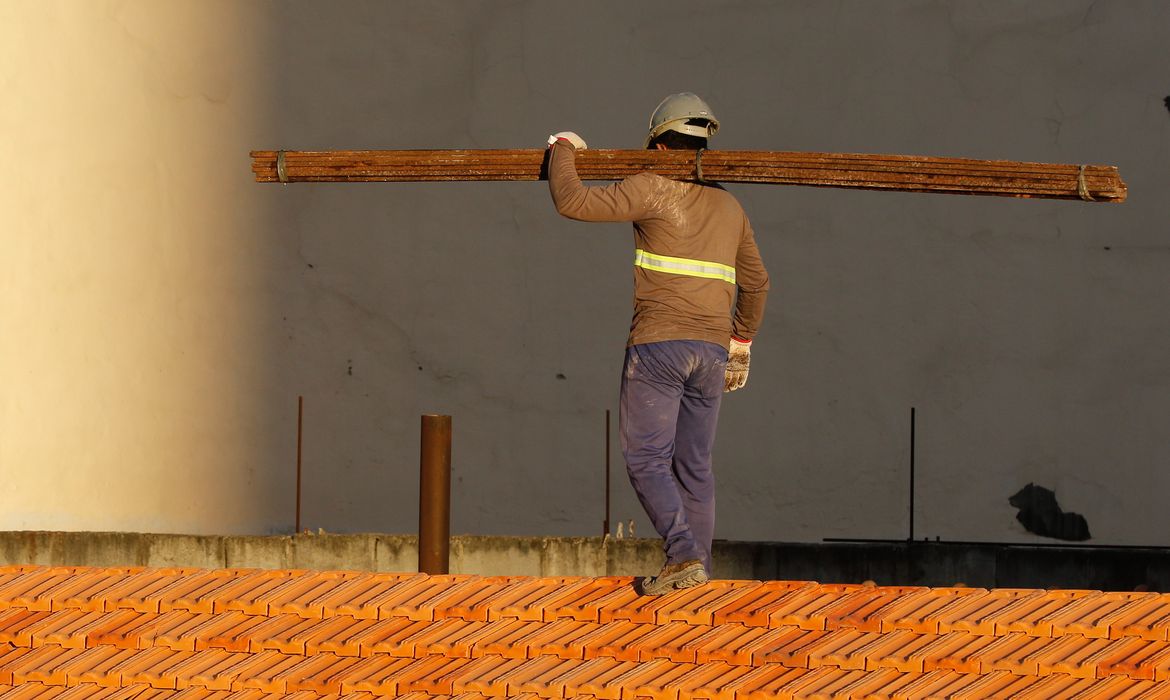 Operários reformam telhado de imóvel em obras no Centro do Rio.