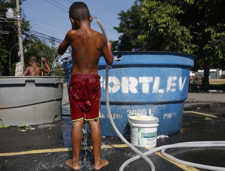 Crianças se refrescam no bairro de São Cristóvão, para amenizar, a onda de calor que  atinge o clima no Rio de Janeiro.