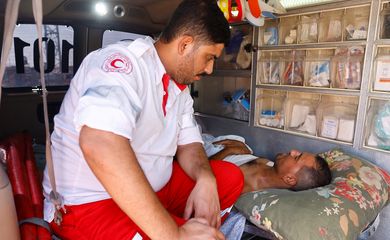 Um profissional de saúde fala com um palestino ferido, que receberá tratamento em um hospital egípcio, no posto fronteiriço de Rafah com o Egito, no sul da Faixa de Gaza, em 1º de novembro de 2023. REUTERS/Ibraheem Abu Mustafa
