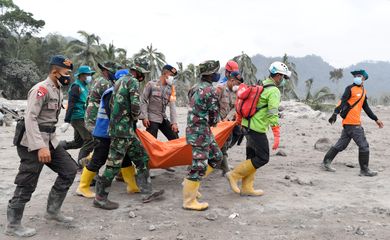 Equipes de resgate carregam vítima de erupção do Semeru, na Indonésia