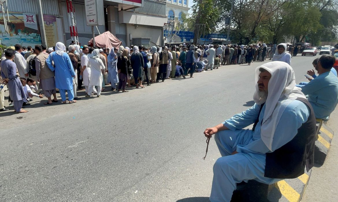 Afghans line up outside a bank to take out their money after Taliban takeover in Kabul