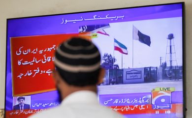 A man looks at a television screen after the Pakistani foreign ministry said the country conducted strikes inside Iran targeting separatist militants, two days after Tehran said it attacked Israel-linked militant bases inside Pakistani territory, in Karachi, Pakistan January 18, 2024. REUTERS/Akhtar Soomro