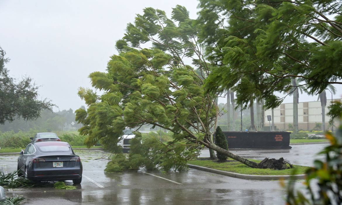Os primeiros ventos do furacão Ian derrubam árvores em estacionamento de hotel em Sarasota, na Flórida. REUTERS/Steve Nesius