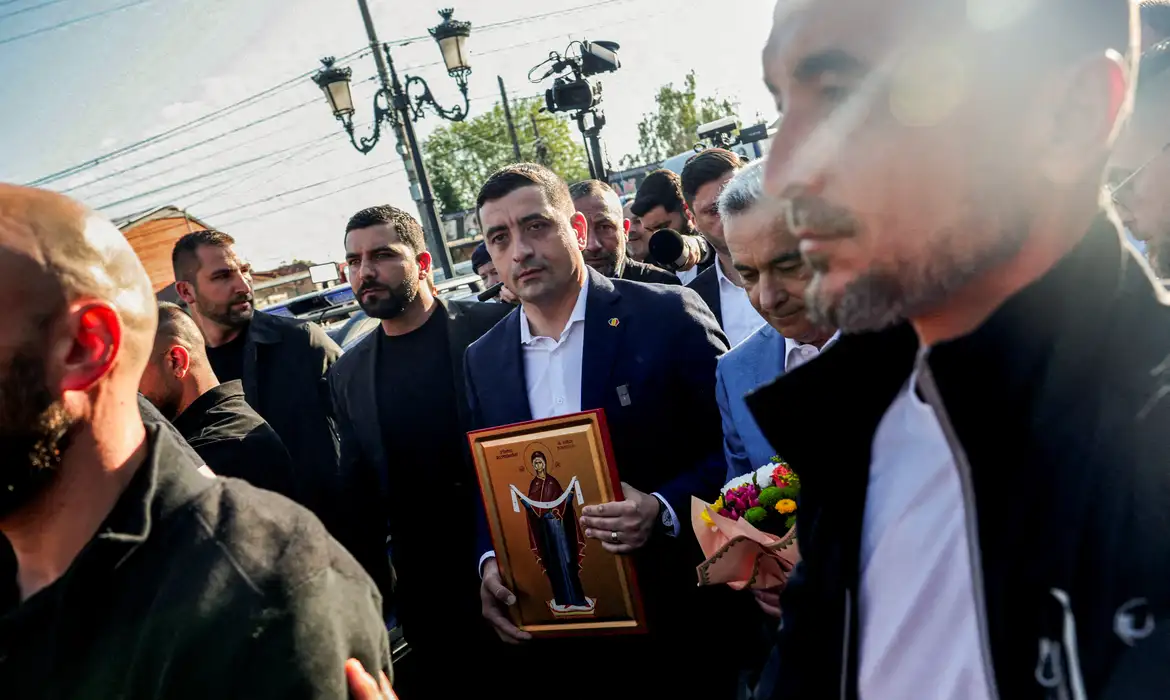 Presidential candidate George Simion walks holding a picture of Romanian holy icon of Protection of the Theotokos presented by a supporter outside a polling station during the country's first round of the presidential election, in Mogosoaia, Romania, May 4, 2025. REUTERS/Louisa Gouliamaki     TPX IMAGES OF THE DAY