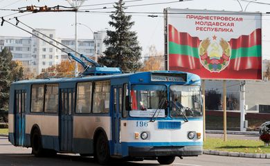 Trolêbus perto de pôster com brazão oficial de armas em Tiraspol, na região separatista da Transnístria, na Moldávia