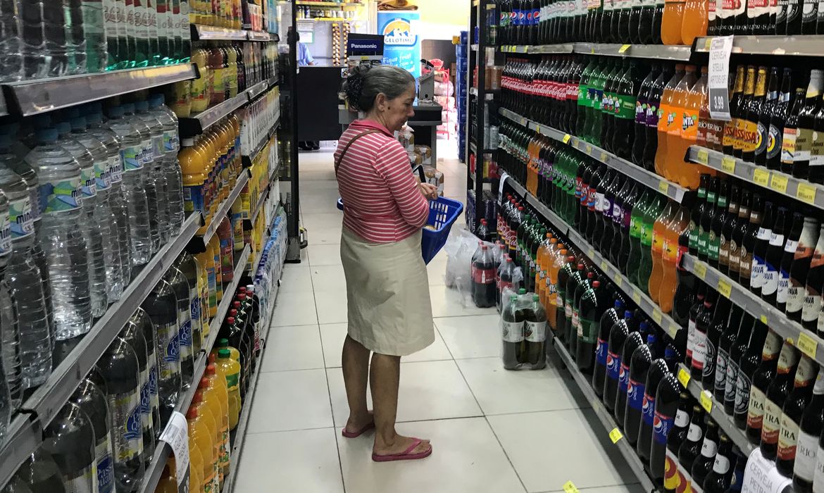 Pessoa procura bebida em supermercado no Rio de Janeiro