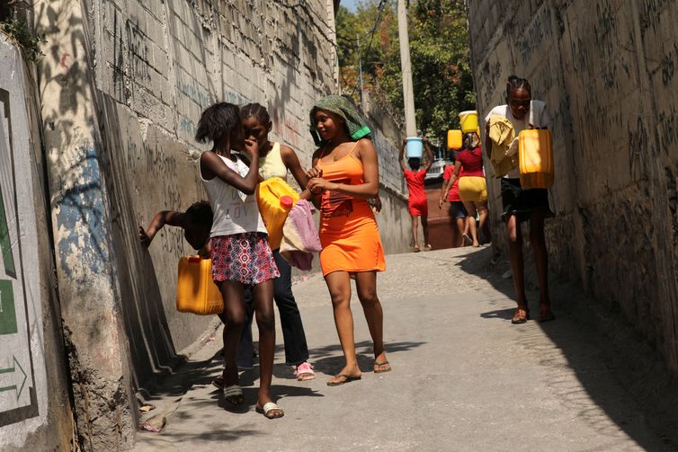 REUTERS/Ralph Tedy Erol Residents carry water jugs to avoid scarcity at home as the government declared a state of emergency amid violence, in Port-au-Prince, Haiti, March 4, 2024. REUTERS/Ralph Tedy Erol REFILE - CORRECTING ACTION FROM