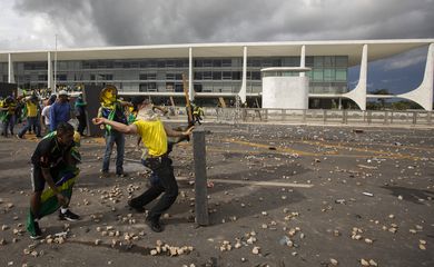 Brasilia 07/02/2023 - Manifestantes invadem predios publicos na praca dos Tres Poderes, na foto manifestantes arrastam grades que ficam na frente do Palacio do Planalto