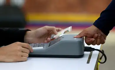 A woman is checked with a fingerprint identity registration device at a polling station in the Liceo Andres Bello during Venezuela's presidential election, in Caracas, Venezuela, July 28, 2024. REUTERS/Fausto Torrealba