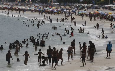 Turistas e cariocas aproveitam o final de semana de verão na praia do Leme.