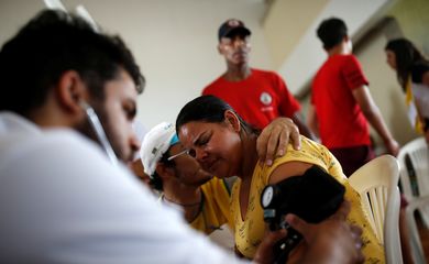 Uma mulher recebe atendimento médico depois que uma represa, de propriedade da mineradora brasileira Vale SA, explodiu em Brumadinho
Uma mulher recebe atendimento médico depois que uma barragem, de propriedade da mineradora brasileira Vale SA,