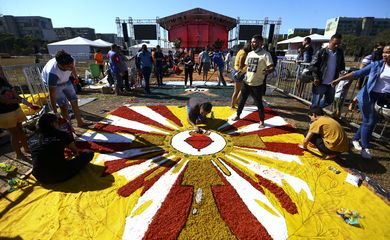 Fiéis confeccionam os tradicionais tapetes de serragem durante a Festa de Corpus Christi de Brasília, que retorna à Esplanada dos Ministérios após 2 anos de celebrações reduzidas por conta da pandemia.