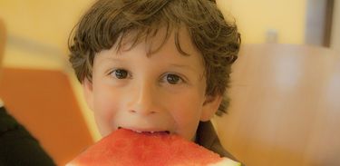 Criança comendo melancia