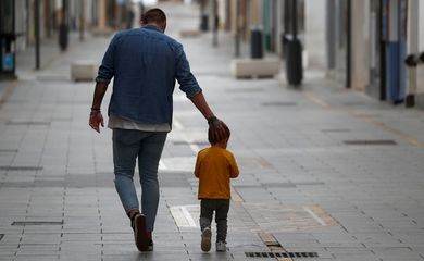 Pai e filho caminham juntos em meio a pandemia de covid-19 na Espanha.