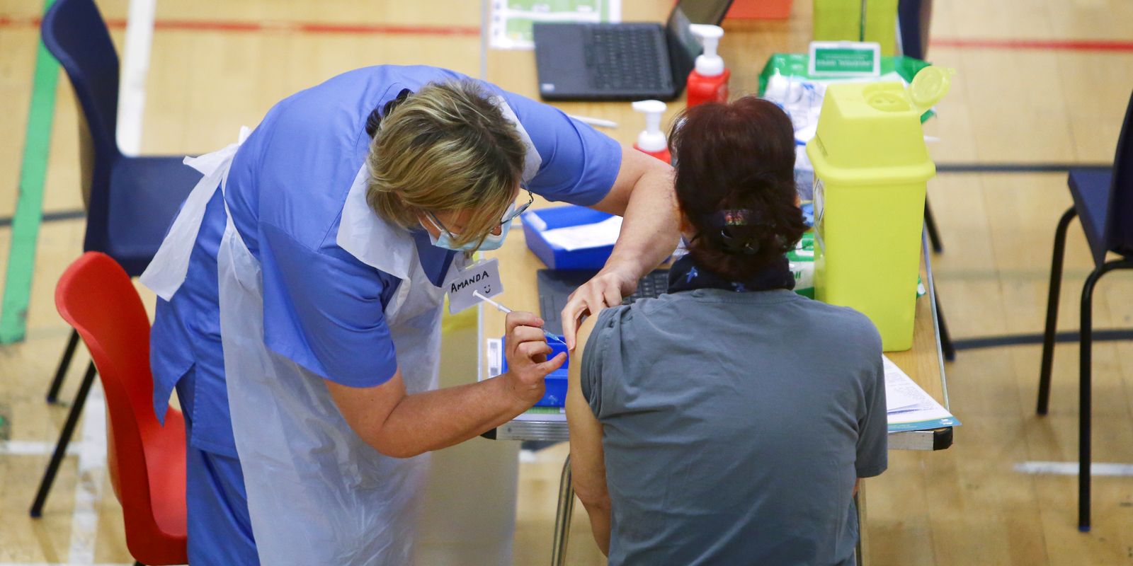 Mulher recebe aplicação de vacina da AstraZeneca contra Covid-19 no estádio de Cwmbran, em Gales do Sul, Reino Unido