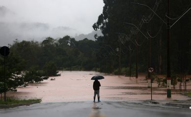 A man stands in front of flooded road near the Taquari River during heavy rains in the city of Encantado in Rio Grande do Sul, Brazil, May 1, 2024. REUTERS/Diego Vara