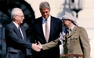 FILE PHOTO: PLO Chairman Yasser Arafat (R) shakes hands with Israeli Prime Minister Yitzhak Rabin (L), as U.S. President Bill Clinton stands between them, after the signing of the Israeli-PLO peace accord, at the White House in Washington September 13, 1993. REUTERS/Gary Hershorn/File Photo