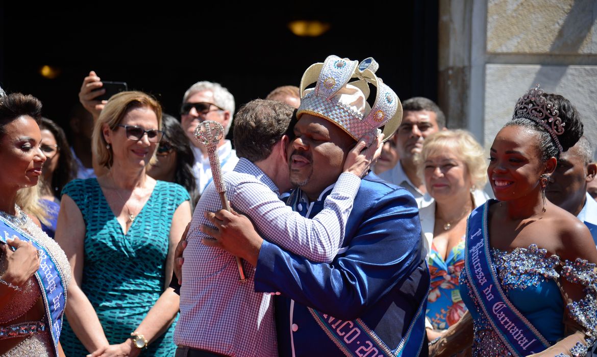 O prefeito Marcelo Crivella abraça o Rei Momo na cerimônia de abertura oficial do carnaval do Rio, no Palácio da Cidade (Tânia Rêgo/Agência Brasil)