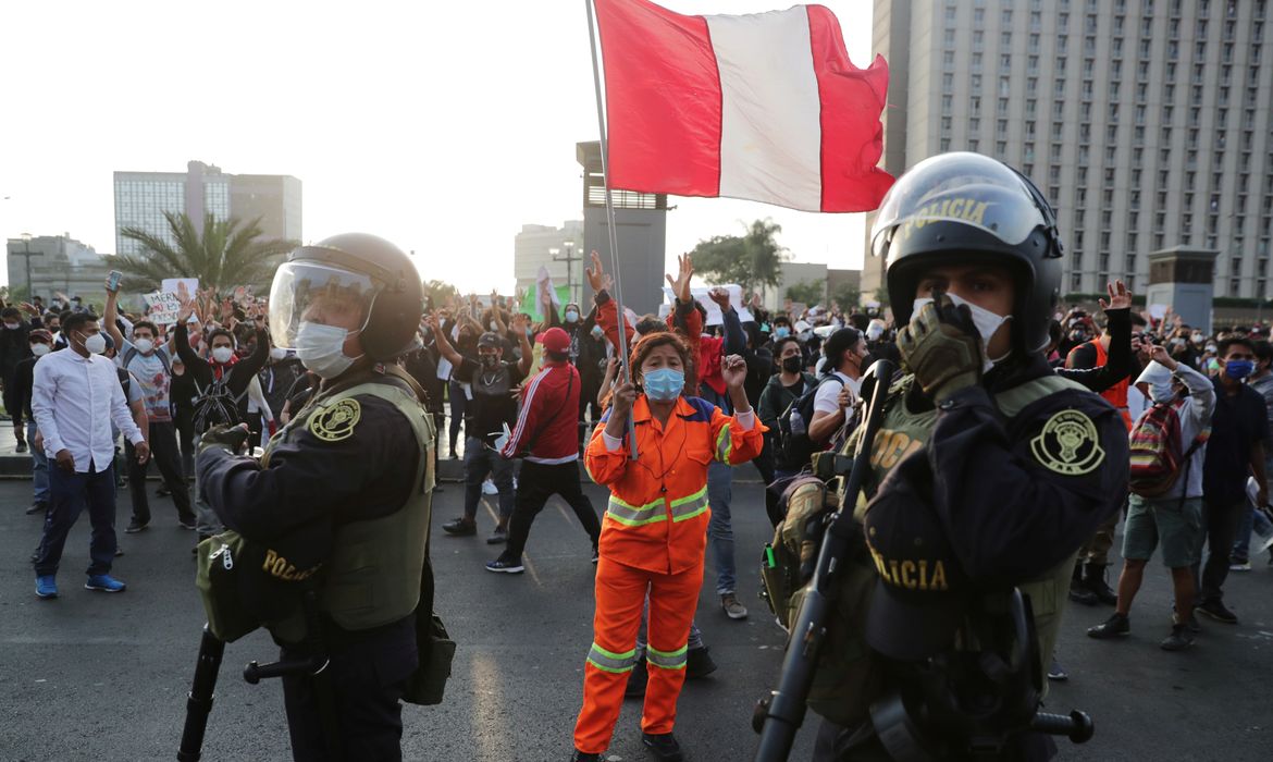 A demonstrator holds a flag during protests following the impeachment of President Martin Vizcarra, in Lima