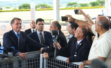 O presidente Jair Bolsonaro fala à imprensa e cumprimenta populares ao sair do Palácio da Alvorada