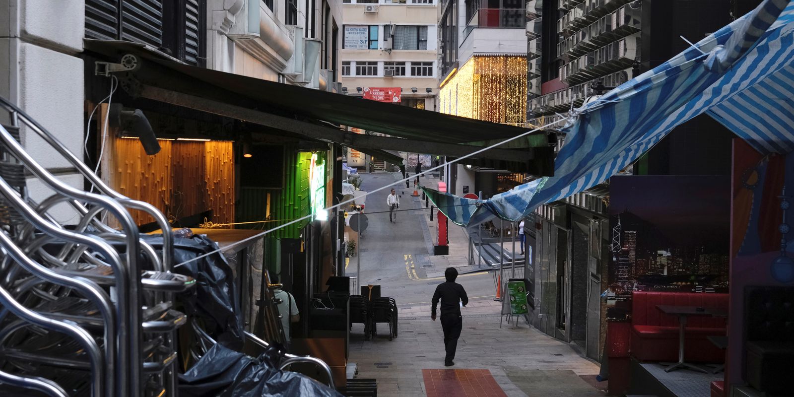 Homem caminha perto de pub fechado por causa da Covid-19 em Hong Kong