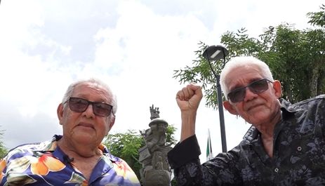 Os ex-vereadores Reginaldo Silva (esq.) e Severino Farias, de Abreu e Lima, PE, em frente ao monumento que celebra o primeiro comício por eleições diretas, em 1983