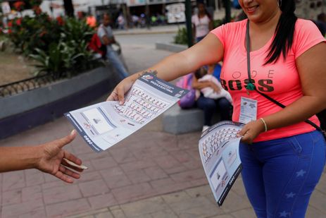 A man receives a flyer of the electoral ballot for the Presidential elections of July 28, in Caracas, Venezuela, July 17, 2024. REUTERS/Leonardo Fernandez Viloria
