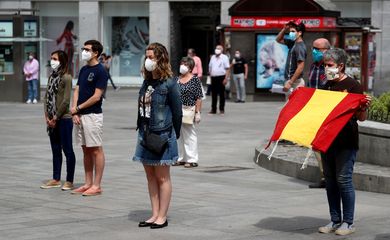 Pessoas com máscaras de proteção durante minuto de silêncio em homenagem às vítimas de Covid-19 em Madri