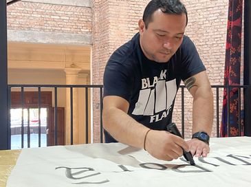 10/06/2023 - O artista indígena Denilson Baniwa trabalhando na Pinacoteca de SP. Foto Aline Beckstein/Divulgação