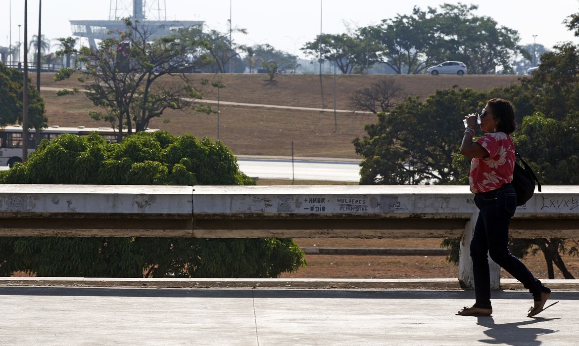 Bruno Peres/Agência Brasil Brasília (DF), 03.09.2024 - Seca e alta temperatura em Brasília. Pessoa com copo de água passa pelo Setor de Diversões Sul. Foto: Bruno Peres/Agência Brasil