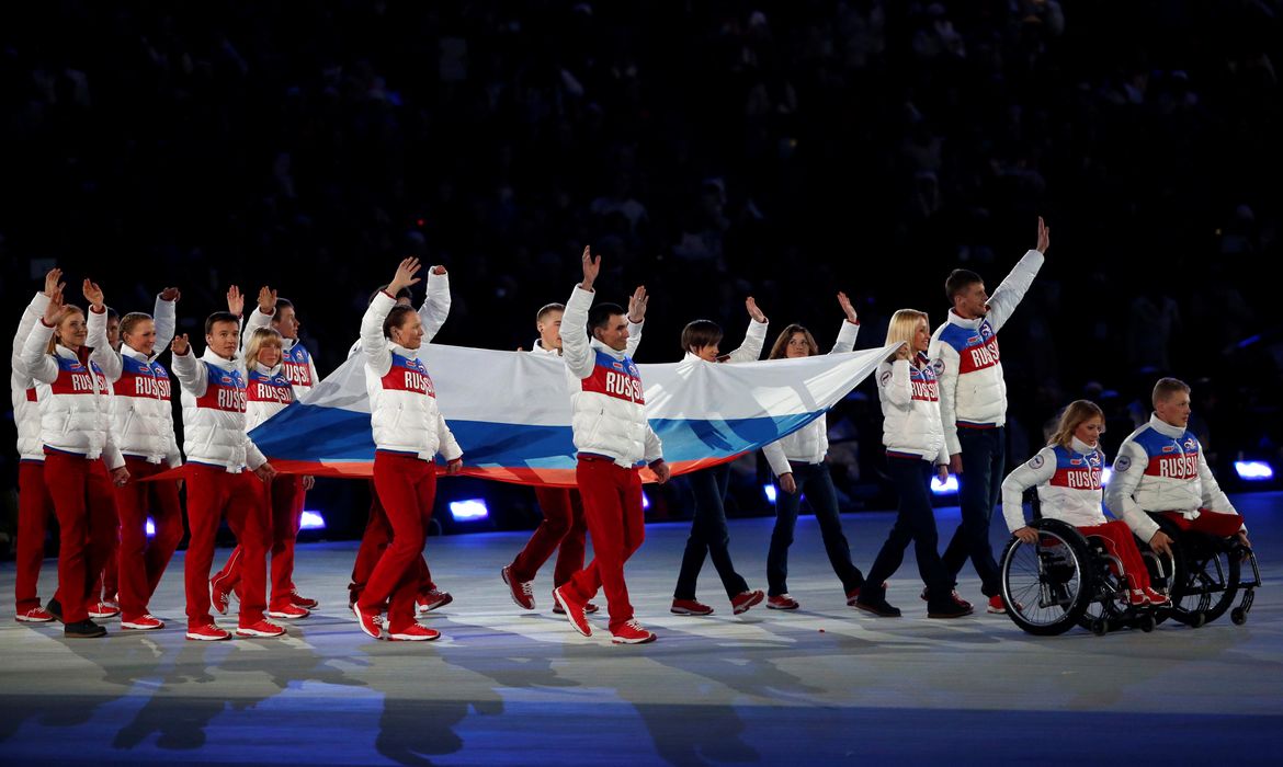 Atletas carregam a bandeira russa durante a cerimônia de encerramento dos 2014 dos Jogos Paralímpicos de Inverno em Sochi, Rússia, em 16 de março de 2014 