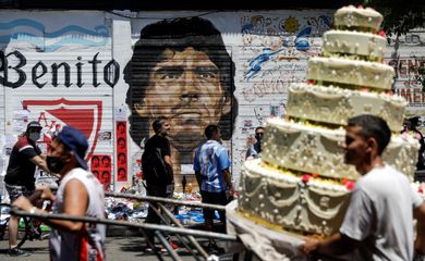 Pessoas passam em frente a grafite de Maradona em Buenos Aires