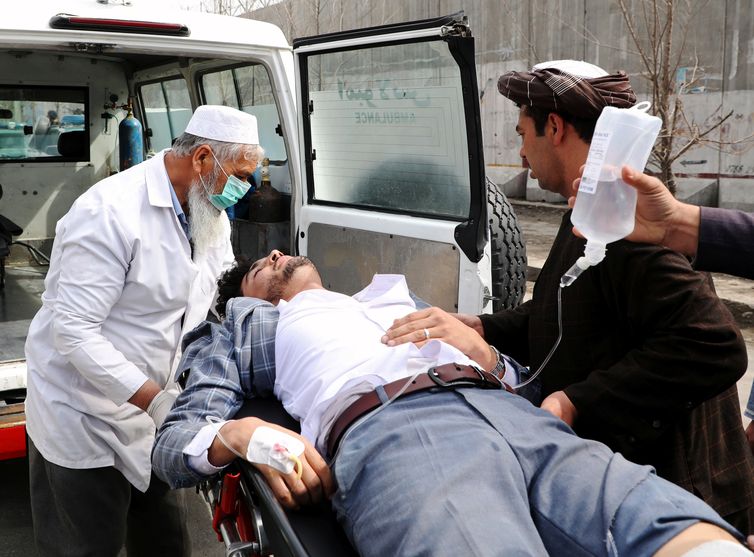 Hospital workers carry an injured person after an attack in Kabul