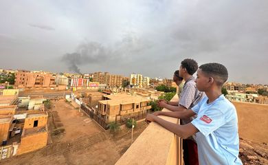 Pessoas observam fumaça em Omdurman
 4/7/2023   REUTERS/Mostafa Saied