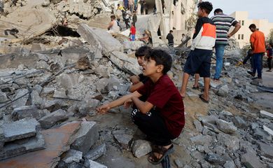 Palestinos observam destroços de prédio destruído em ataque israelense em Khan Younis
17/10/2023
REUTERS/Mohammed Salem