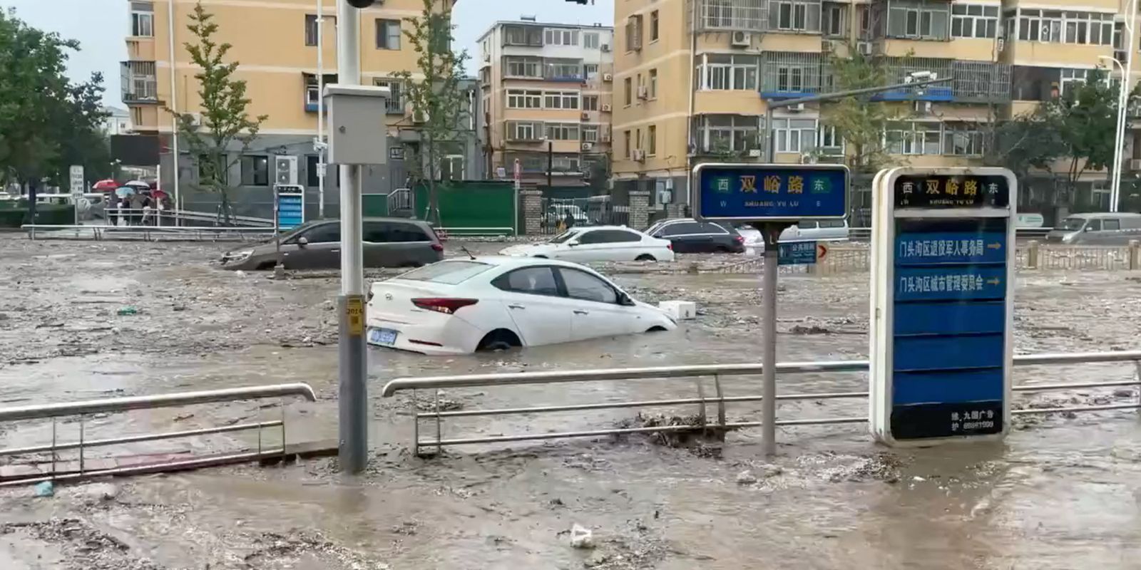 Water gushes on a flooded street following Typhoon Doksuri in Beijing
