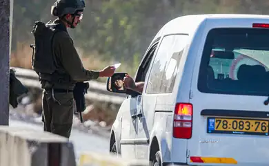 An Israeli soldier checks the phones of Palestinians who pass through an Israeli military point, near the site of the shooting of an Israeli soldier at the gate of the Jewish settlement of Kedumim in the West Bank. A Palestinian carried out a run-over and shooting attack on an Israeli soldier, which led to his death. The Israeli army forces chased the perpetrator and killed him minutes after carrying out the operation. Reuters/Nasser Ishtayeh/Proibida reprodução