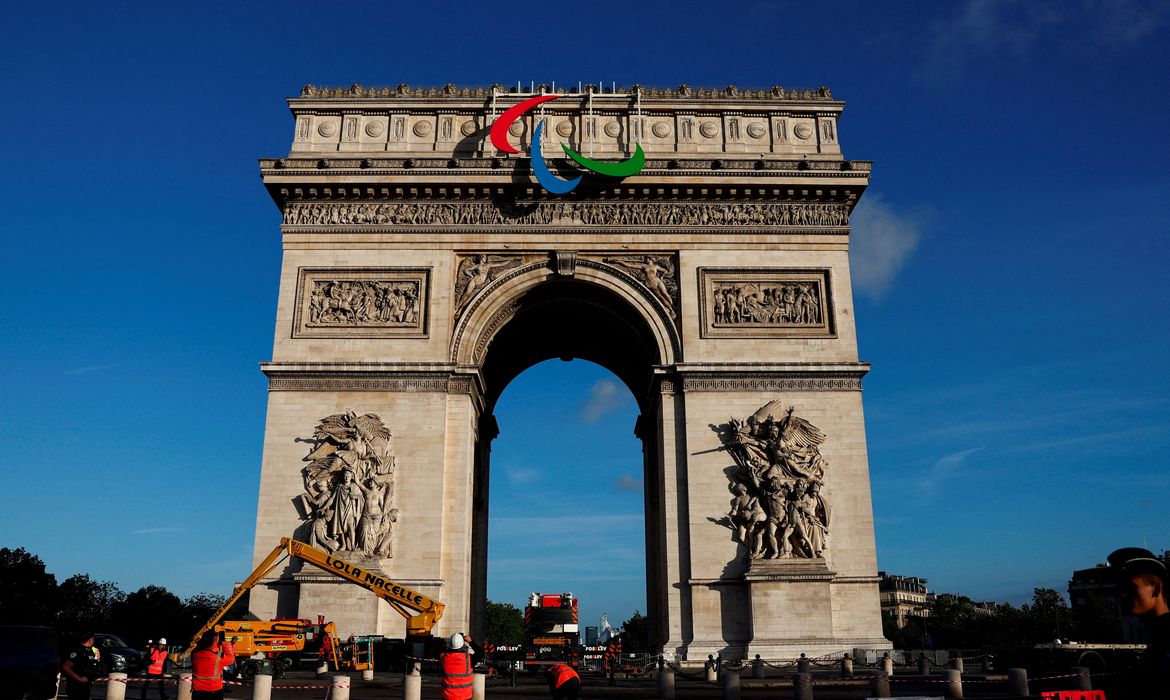 Workers stand next to the Arc de Triomphe with the Paralympic Games symbol attached to it, ahead of the Paris 2024 Olympic and Paralympic Games, in Paris, France, June 28, 2024. REUTERS/Gonzalo Fuentes
