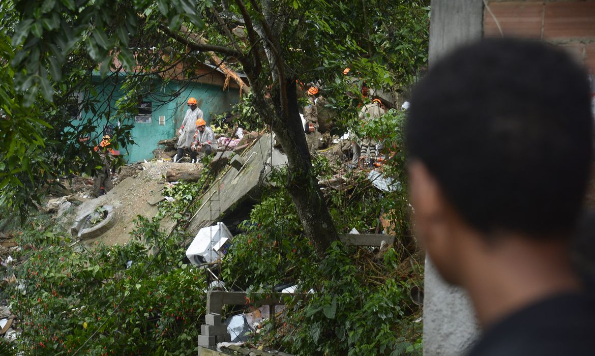Bombeiros trabalham no Morro da Babilônia, no Leme, zona sul da cidade,  para resgatar o corpo de um homem que está soterrado devido ao deslizamento provocado pelo temporal que atingiu a cidade do Rio de Janeiro