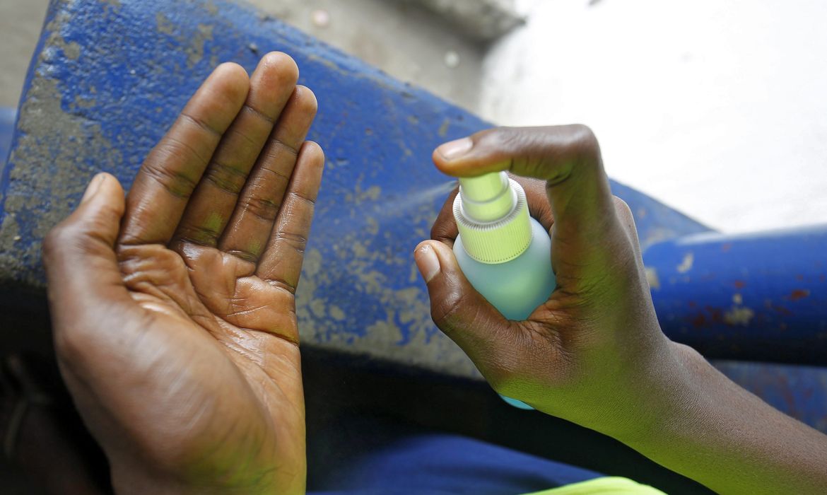 Menino higieniza mãos para evitar transmissão do Ebola