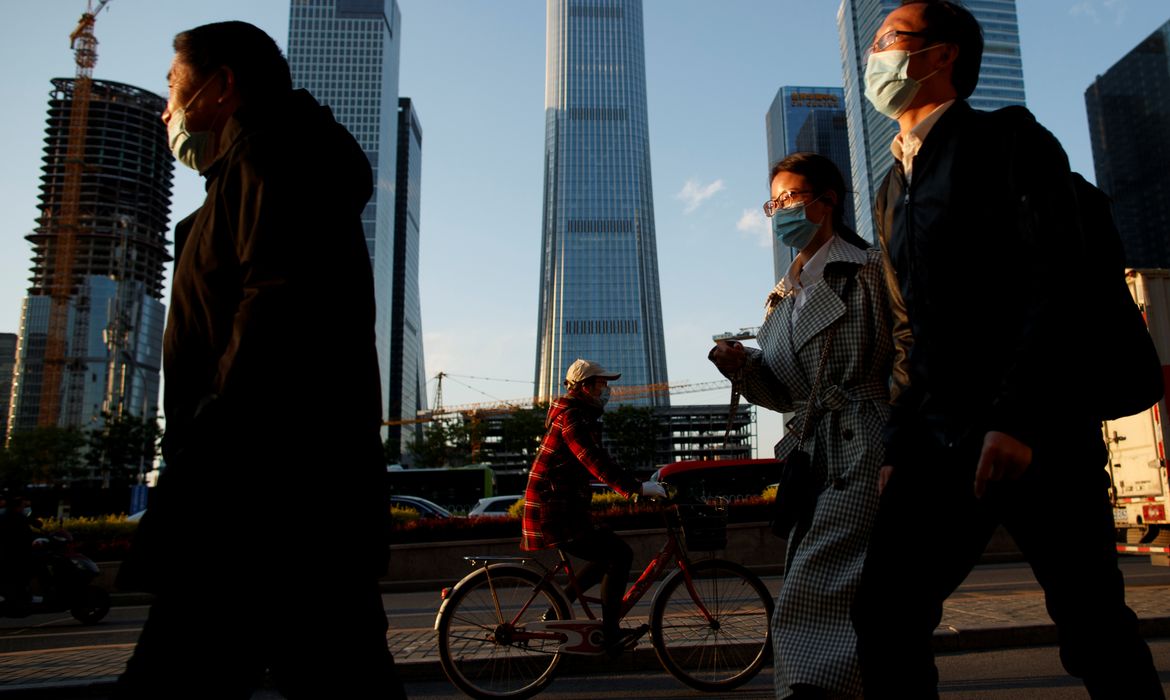 People wear protective masks as they leave work during evening rush hour in Beijing as the spread of the novel coronavirus disease (COVID-19) continues