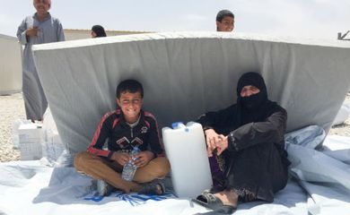 Famílias buscam abrigo no novo acampamento para deslocados da Acnur, no Iraque