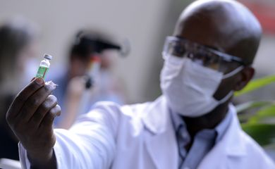 Servidor da Fiocruz prepara vacina de Oxford/AstraZeneca para a primeira aplicação no Brasil.