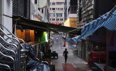Homem caminha perto de pub fechado por causa da Covid-19 em Hong Kong