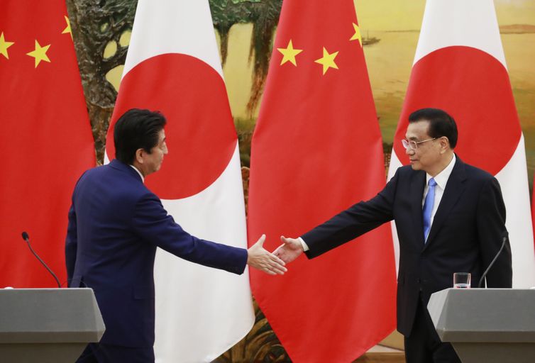 HHY01. PEKÍN (CHINA), 26/10/2018.- El primer ministro japonés, Shinzo Abe (i), y el primer ministro chino, Li Keqiang (d), se dan la mano después de una conferencia de prensa en el Gran Palacio del Pueblo en Beijing, China, el 26 de octubre de