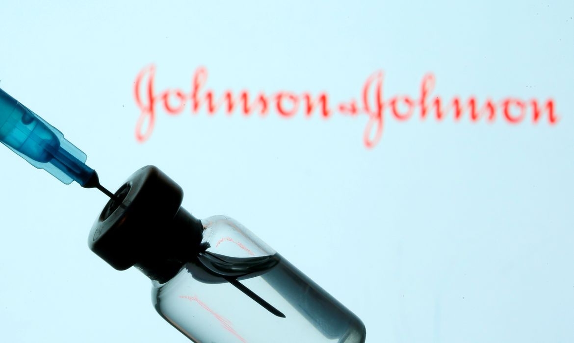 FILE PHOTO: Vial and sryinge are seen in front of displayed Johnson&Johnson logo in this illustration taken