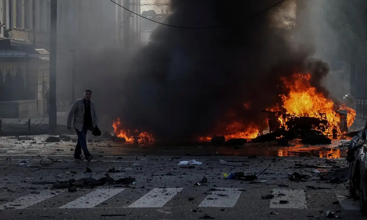 A driver walks near his burned car after Russian military strike, as Russia's invasion of Ukraine continues, in central Kyiv, Ukraine October 10, 2022.  REUTERS/Gleb Garanich     TPX IMAGES OF THE DAY